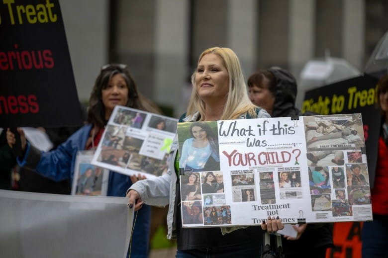 Kimberlee Booth, center, of San Luis Obispo marches with other supporters following speeches at a rally in support of Prop. 1 at the state Capitol on Jan. 31, 2024. The proposition aims to reform mental healthcare in the state. Photo by José Luis Villegas for CalMatters
