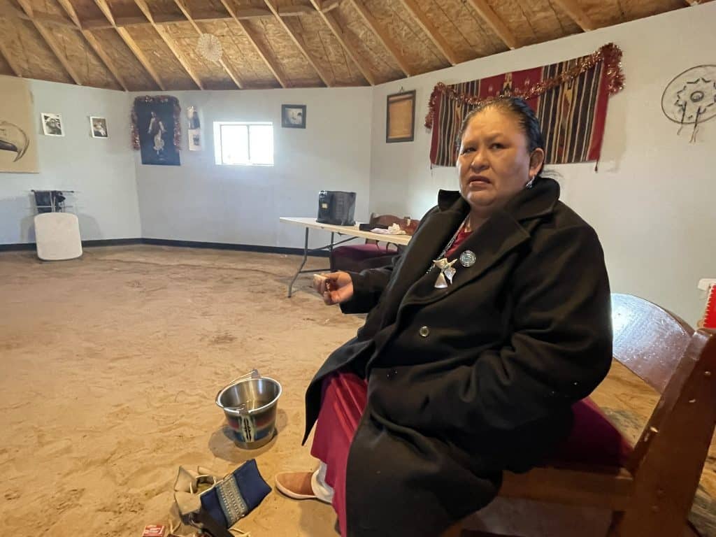 A woman looks to the camera in an indigenous ritual space for a story about the five-year COVID anniversary and indigenous communities