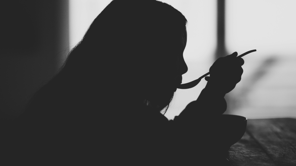 silhouette of a person eating in the dark